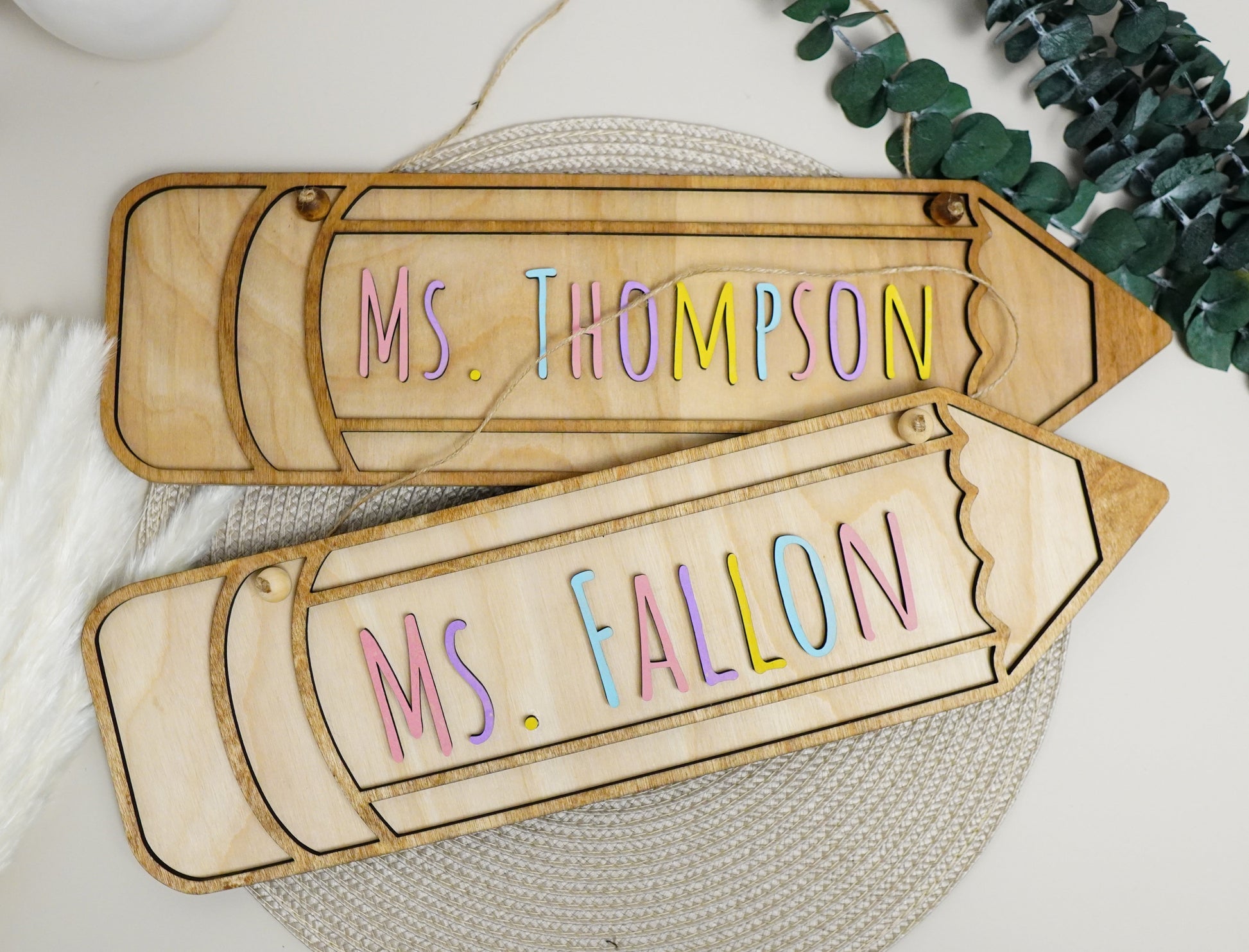 Wooden nameplates with 'Ms. Thompson' and 'Ms. Fallon' on a decorative background